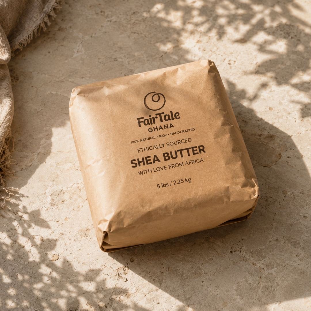 A 5 lb brown paper bag of FairTale Ghana Shea Butter, photographed from an overhead angle on a textured beige stone surface with dappled sunlight and shadows.